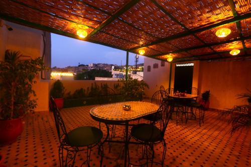 a patio with a table and chairs and a view at Dar Ibn Majdoub Lala aicha & Alia in Fès