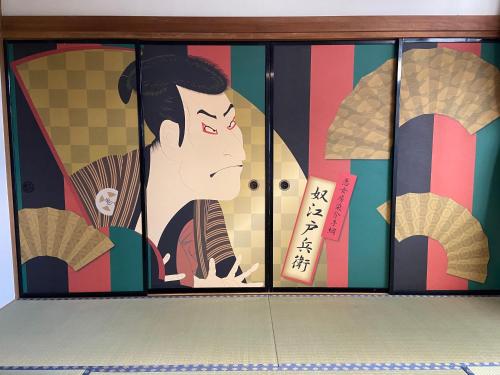 a glass door with a painting of a woman at 慶村 歌舞伎 in Fujikawaguchiko