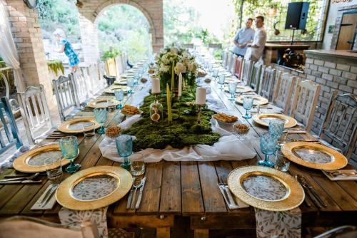 a long wooden table with plates of food on it at Pensiunea Boema in Lancrăm