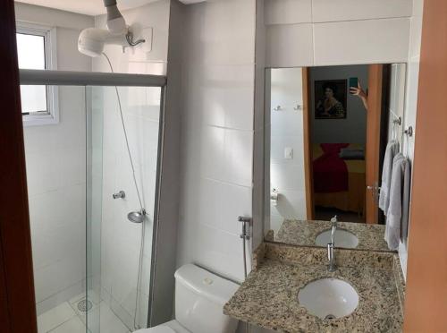 a bathroom with a toilet and a sink and a shower at Apartamento New Wave - 2 quartos Setor Bueno in Goiânia