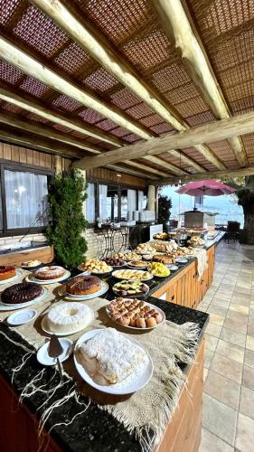 ein Buffet mit vielen Tellern mit Essen auf einem Tisch in der Unterkunft Hotel Pé na Areia in Penha