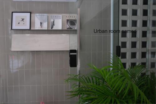 a bathroom with a towel dispenser on a tiled wall at Urban room samed in Ko Samed