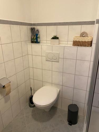 a bathroom with a toilet in a white tiled wall at Monteurwohnung in 94405 Landau an der Isar in Landau an der Isar