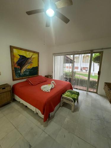 a bedroom with a bed with a red blanket and a window at HAB PTa B ÁREA DE VILLAS DENTRO DEL HOTEL Junto al Krystal EN IXTAPA WIFI 2A 1M Con playa in Ixtapa