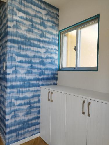 a bathroom with a window and a white cabinet at Breath of the Sea Katakai in Katakai