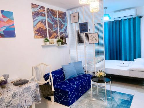 a living room with a blue couch and a table at Blue Diamond Staycation beside Enchanted Kingdom in Santa Rosa Laguna in Santa Rosa