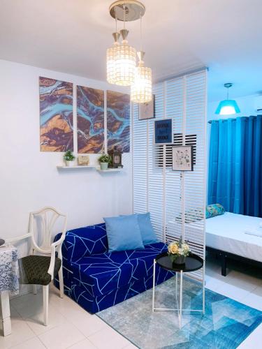 a living room with a blue couch and a bed at Blue Diamond Staycation beside Enchanted Kingdom in Santa Rosa Laguna in Santa Rosa