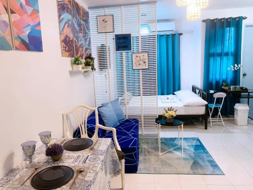 a living room with blue curtains and a table with chairs at Blue Diamond Staycation beside Enchanted Kingdom in Santa Rosa Laguna in Santa Rosa