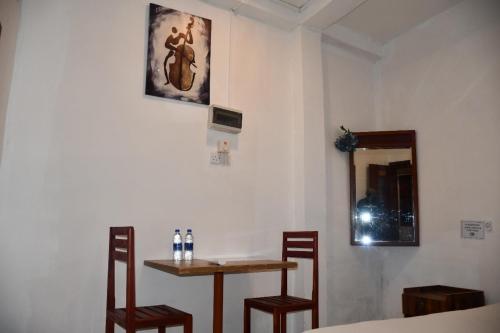 a room with a table and two chairs and a mirror at Cinnamon Airport Residencies in Katunayaka