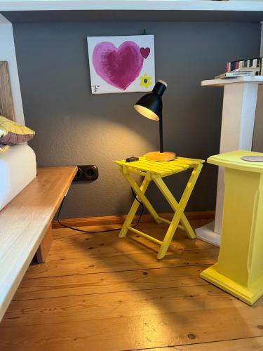 a yellow table with a lamp in a room at Apartment Waldkauz in Weilersbach