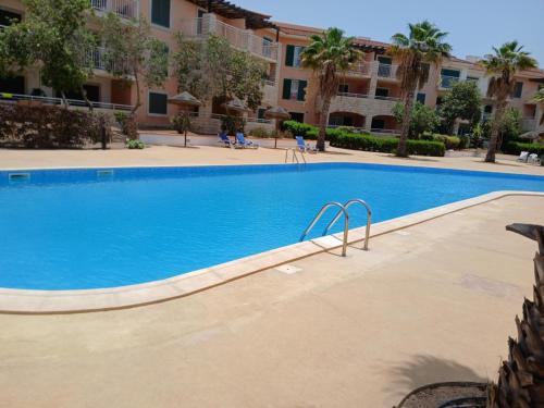 a swimming pool at a resort with palm trees and buildings at Holiday Home - Santa Maria in Prainha