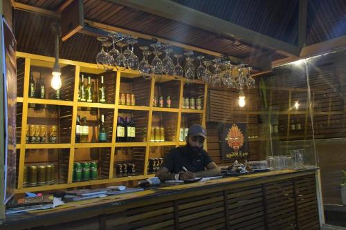 a man sitting at a counter in a bar at Cinnamon Airport Residencies in Katunayaka