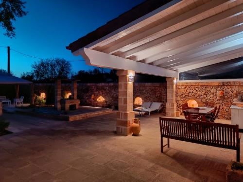 a patio with a fireplace and a wooden bench at Appartamento Località Galato in Castrignano del Capo