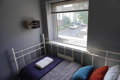 a bed in a room with a window at Luxury Rooms - Pick a Room - Free Parking & Kitchen Access, Near Etihad Stadium, The Coop Live & Piccadilly Station, Manchester in Manchester