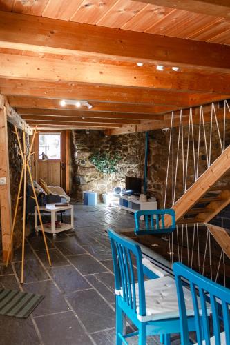 a room with two blue chairs and a wooden ceiling at Casa de Pombares in Veigas