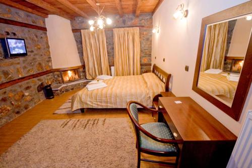 a bedroom with two beds and a desk and a mirror at Guesthouse Toitos in Palaios Agios Athanasios