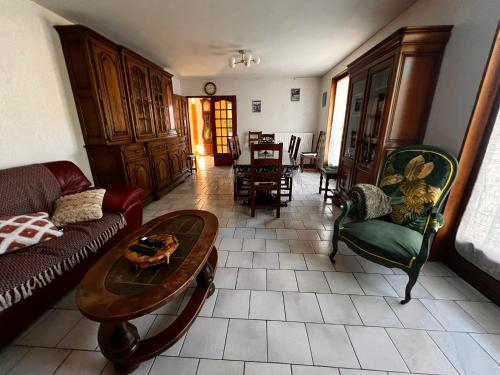 a living room with a couch and a table and chairs at Gîte de la petite Reine in Champagney