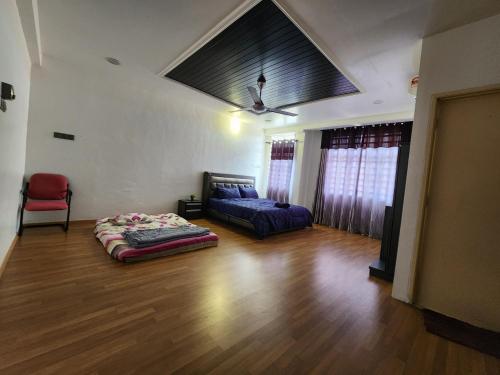 a bedroom with a bed and a couch in a room at Shakira homestay in Kota Bharu