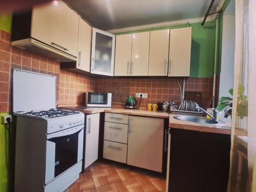 a small kitchen with white appliances and green walls at Міні готель Еней in Kyiv