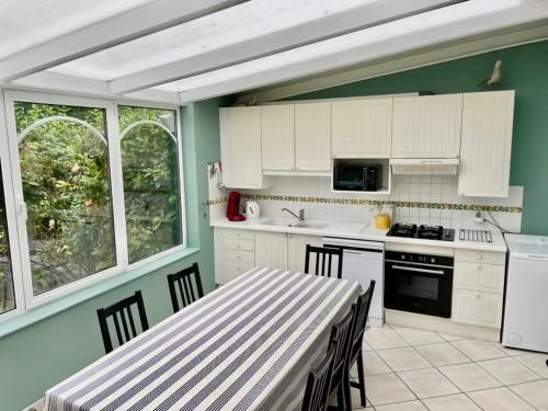 eine Küche mit weißen Schränken und einem Tisch mit Stühlen in der Unterkunft Villa Barracuda in Le Touquet-Paris-Plage