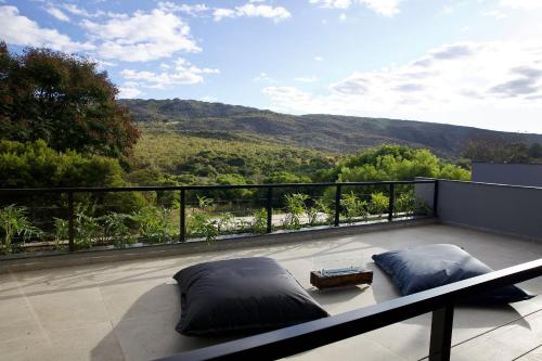 a balcony with pillows and a view of the mountains at Casa Nengueta - Lapinha da Serra in Santana do Riacho