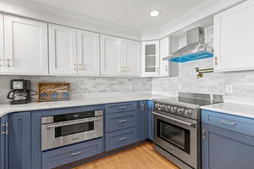 a blue kitchen with white cabinets and a stove at The New Oceanic Inn in Old Orchard Beach