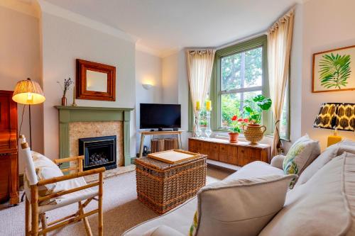 a living room with a fireplace and a tv at Pass the Keys Charming Victorian Terrace in centre of Cambridge in Cambridge