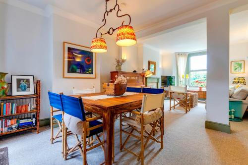 a dining room with a wooden table and blue chairs at Pass the Keys Charming Victorian Terrace in centre of Cambridge in Cambridge