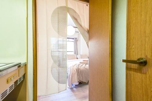 una porta che conduce a una camera con letto di New! Japandi 3 1BR in Prime Location-1 min to STN a Hakata