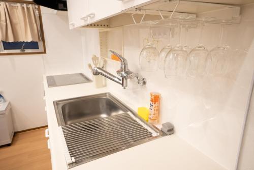 una cocina con fregadero y gafas en la pared en 花宿浅草二番 Hanayado Asakusa2, en Tokio