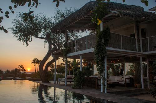 a villa with a pool and a sunset in the background at Villa Praia - La Villa Group in Jericoacoara