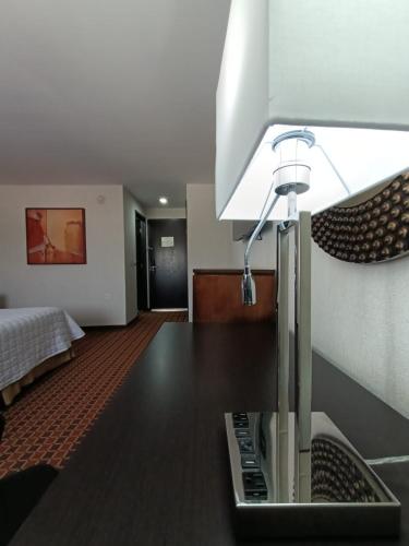 a room with a table with a lamp on it at Paris FC Hotel in Poza Rica de Hidalgo