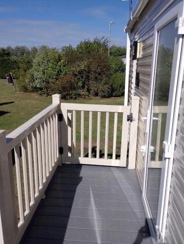 a porch with a white fence and a door at Happy Havan in Great Yarmouth