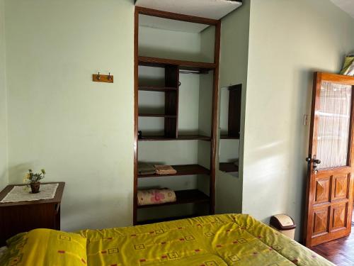 a bedroom with a bed and a book shelf at Habitación con baño privado in Sucre