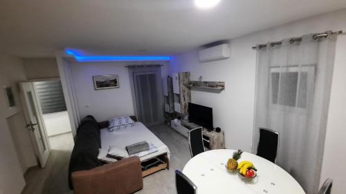 a living room with a table and a room with a bed at Apartman Iva in Podstrana