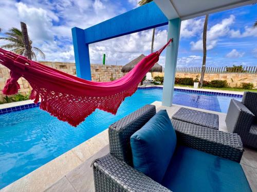 a hammock is hanging over a swimming pool at Ocean front privacy and comfort! in Pitangui
