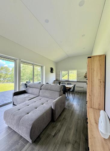 a living room with a large couch and a table at Kaštonų krantas in Antotylʼtse