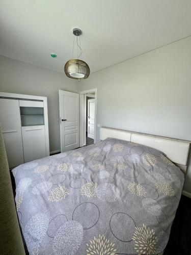 a bedroom with a bed with a patterned blanket at Kaštonų krantas in Antotylʼtse