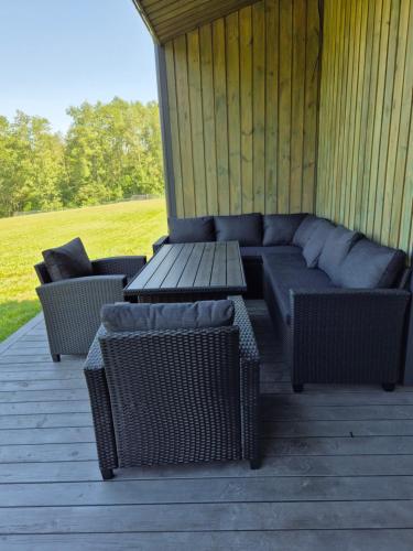 a patio with a couch and chairs on a deck at Kaštonų krantas in Antotylʼtse
