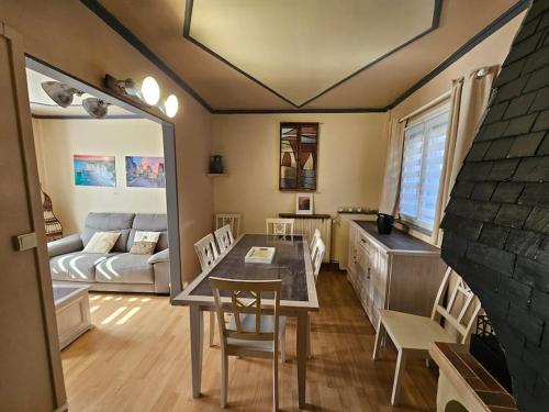 un salon avec une table, des chaises et un canapé dans l'établissement Les Caloges , maison avec terrasse, à Étretat
