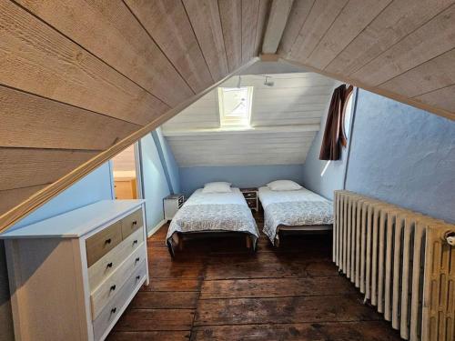 une petite chambre avec deux lits et une fenêtre dans l'établissement Les Caloges , maison avec terrasse, à Étretat