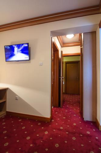a hallway of a hotel with a flat screen tv on the wall at Hotel Cezar Banja Luka in Banja Luka