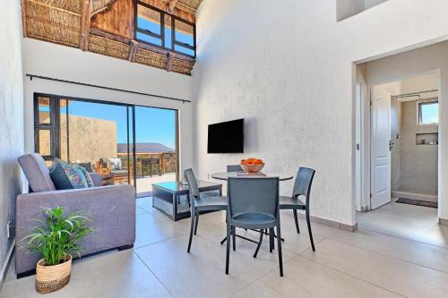 a living room with a table and chairs and a tv at Thula-Thula Private Game Lodge Mabalingwe in Bela-Bela
