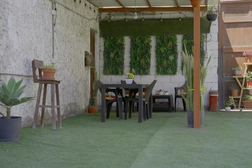 a patio with a table and chairs and plants at Hotel San Martín in San Juan de Marcona