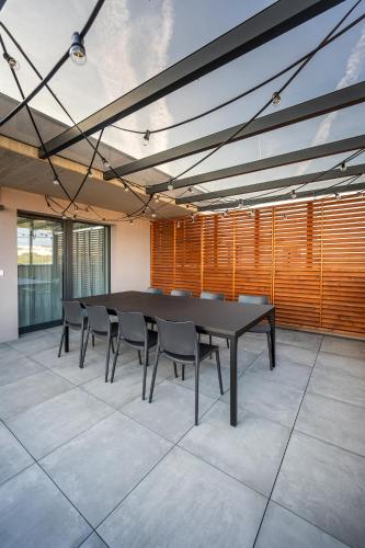 a conference room with a black table and chairs at SkyLuxe Old Town Penthouse in Košice