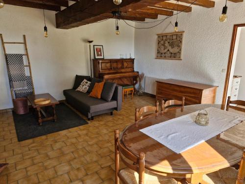 a living room with a table and a couch at Charmante maison à la campagne in Maisoncelles
