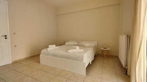 a bedroom with a white bed with towels on it at Messinian Aura in Arkondikó