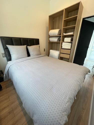 une chambre avec un grand lit avec des draps blancs dans l'établissement Studio Appart 35m, à Rosny-sous-Bois