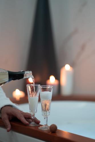 a person pouring champagne into two glasses on a table at Love Me Nemi in Nemi