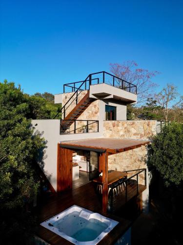 a house with a wooden table and a swimming pool at Casa Nengueta - Lapinha da Serra in Santana do Riacho